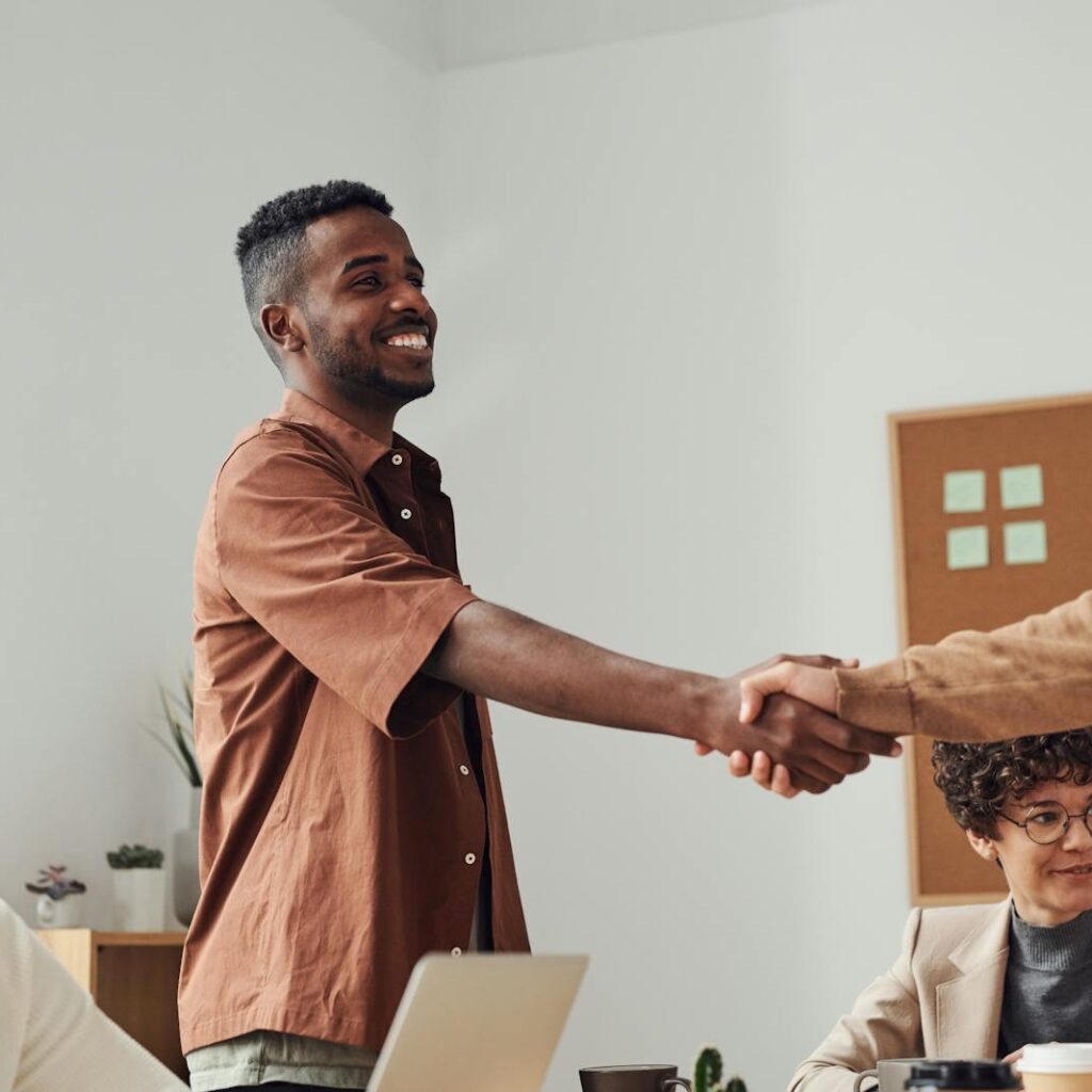 Man in Brown Sport Shirt Shaking Hands of Man