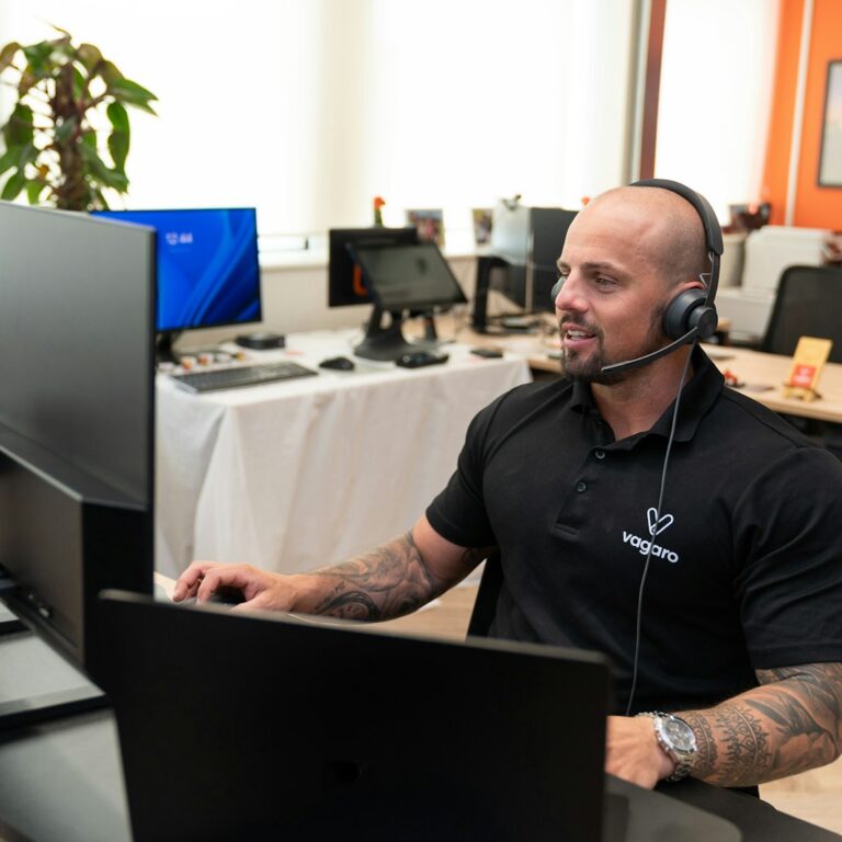 a man wearing a headset sitting in front of a computer