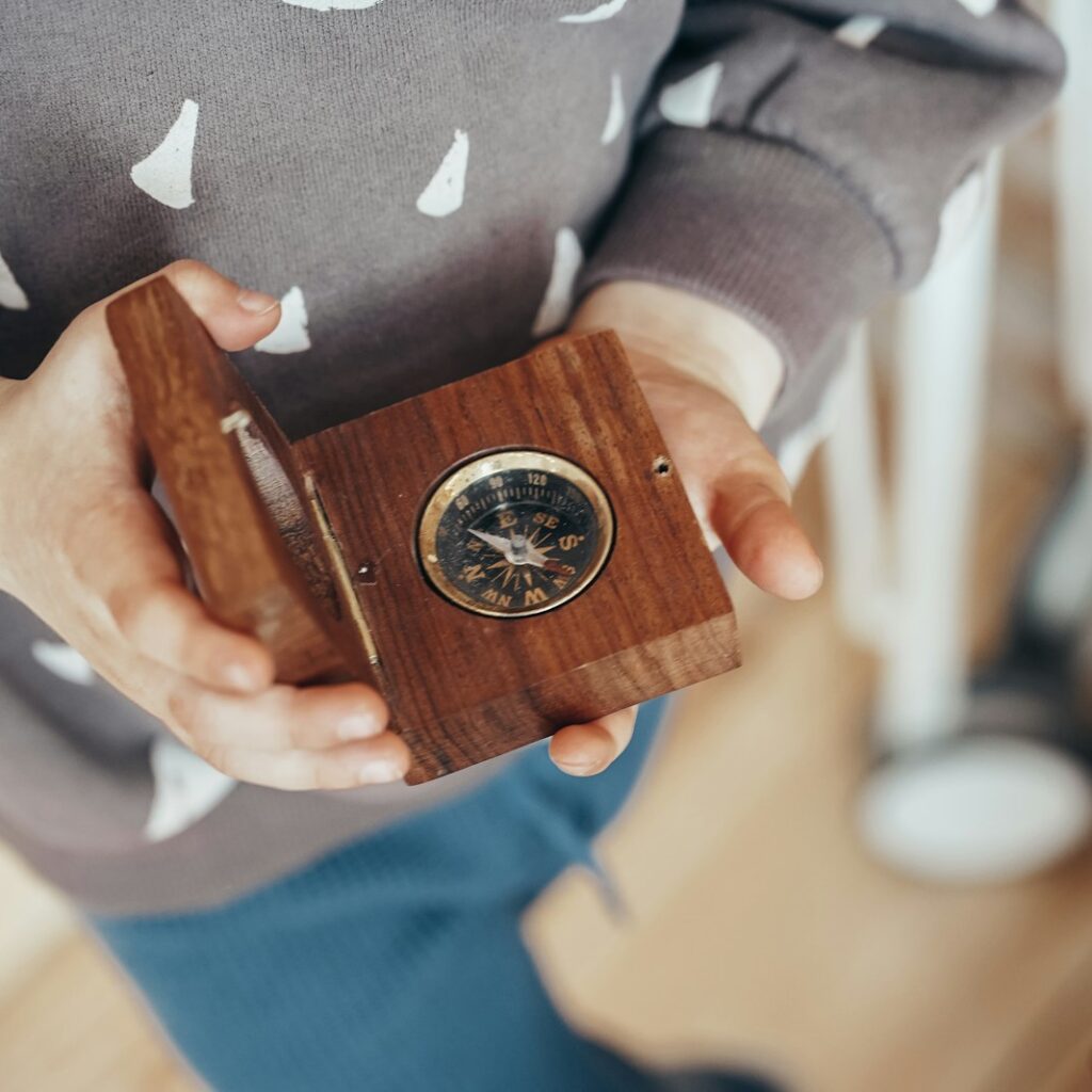 person in gray and white star print long sleeve shirt holding brown wooden box