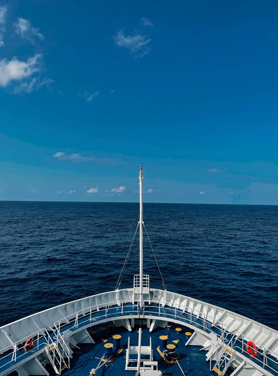 white boat on sea under blue sky during daytime